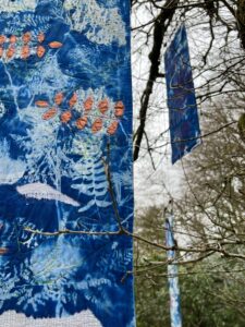 quilts by Gillian Cooper hanging around an oak tree